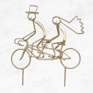 gold bride and groom riding a tandem cake topper