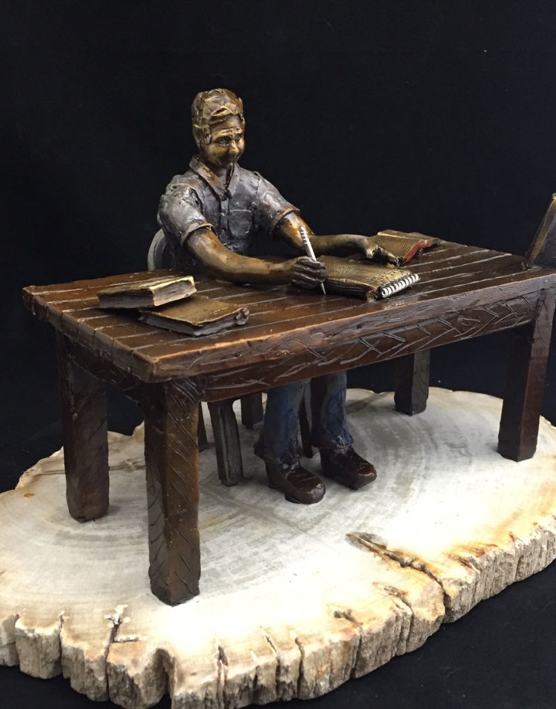 bronze sculpture of a man writing